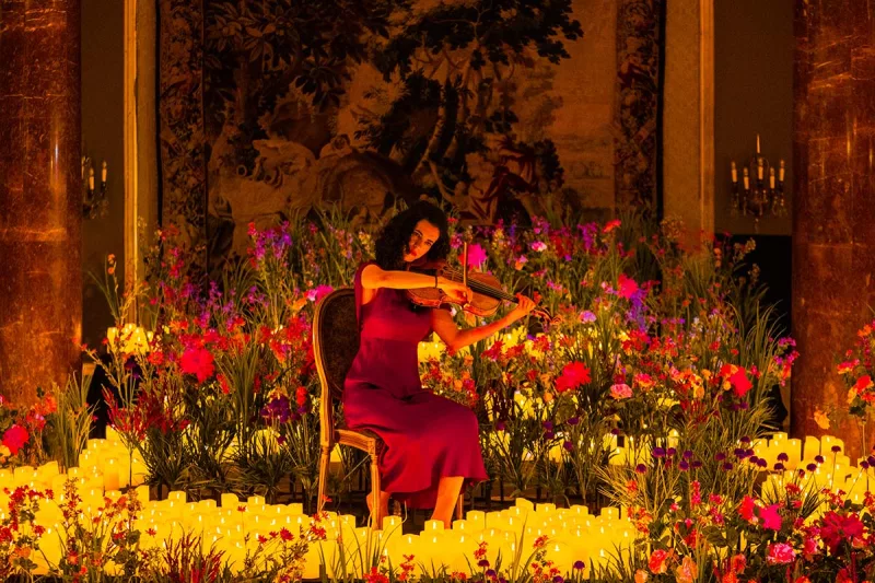 Músicos tocando concierto a la luz de las velas en edificio histórico